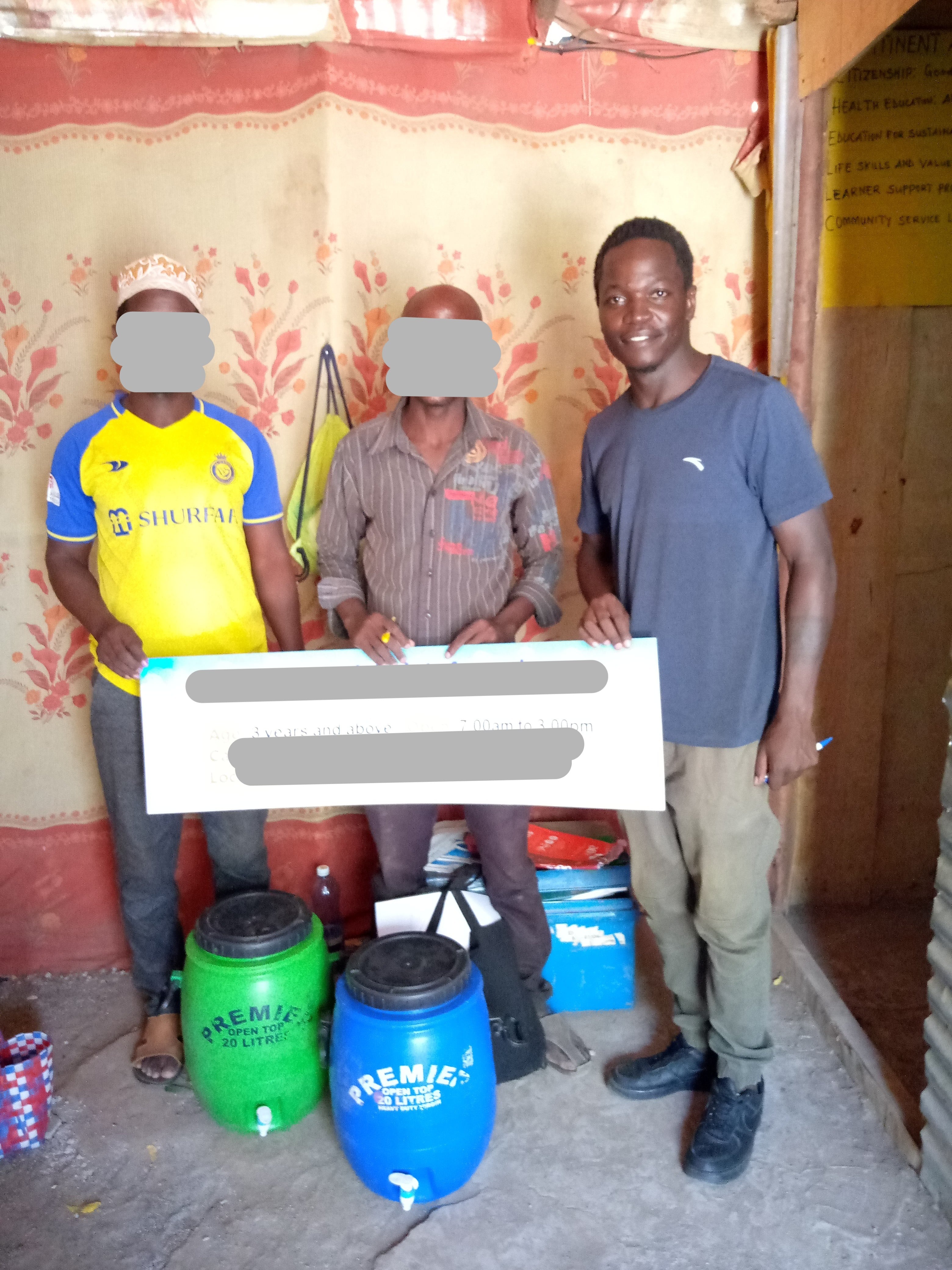 local-community-members-holding-sign-and-water-barrels